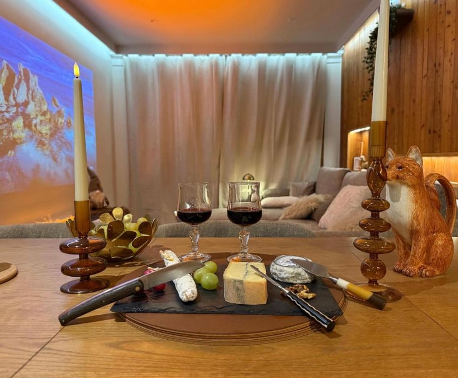 Una mesa con dos copas de vino y una bandeja de queso. en Appart 60 M2 pied pistes terrasse Vars les Claux, en Vars