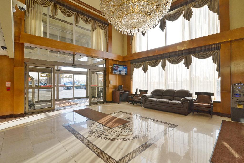sala de estar amplia con sofá y lámpara de araña. en Woodbine Hotel & Suites, en Toronto