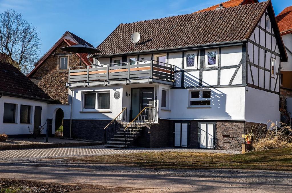 a large white and black house with a porch at Ferienhaus Lotte in Vöhl