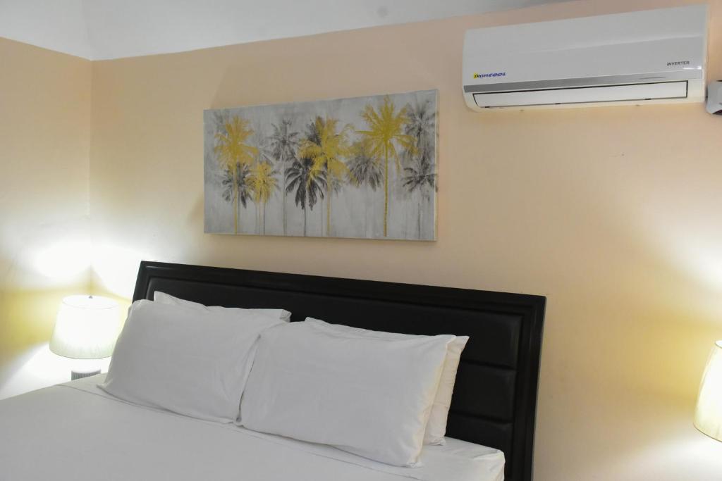 a bedroom with a bed and a picture of palm trees at Jevico's Cozy Villa in Priory