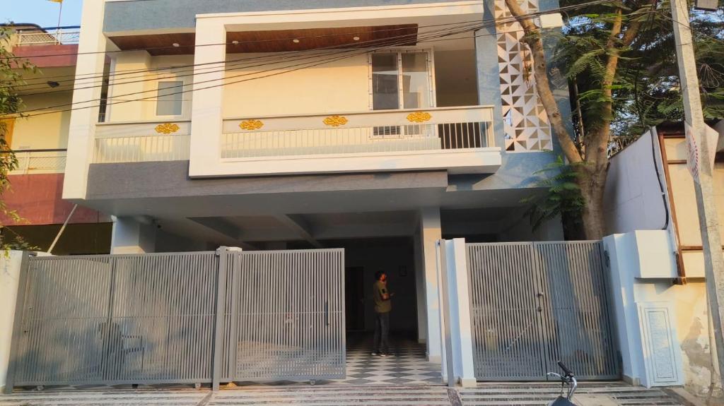 Eine Frau steht vor einem Haus mit einem Tor. in der Unterkunft Hostro Stays in Jaipur