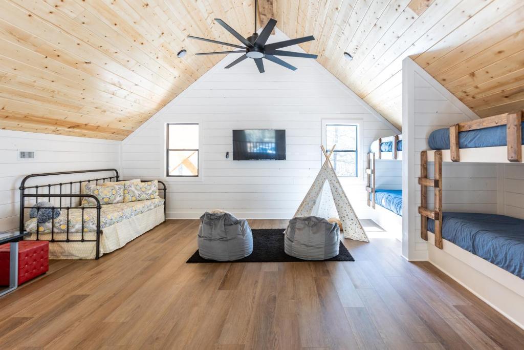 une chambre avec deux lits superposés et un plafond en bois dans l'établissement Crimson Creek Cabin - Hot Tub, Playset, Family-Friendly, à Broken Bow