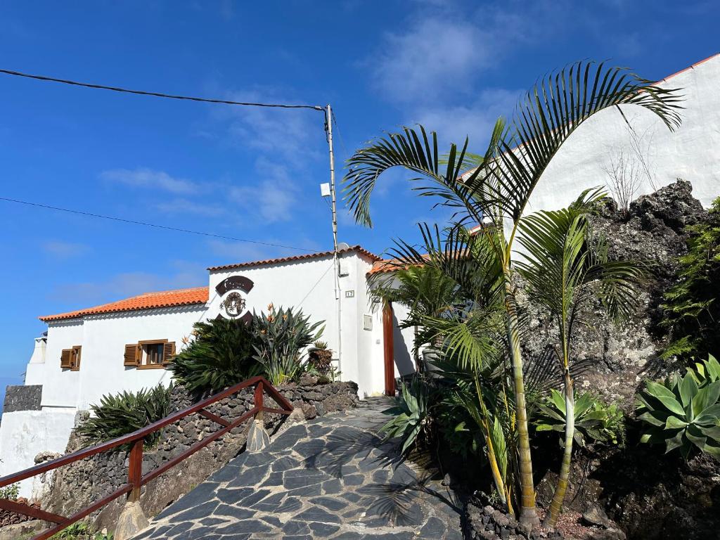 a building with a palm tree in front of it at Finca La Hoya 1-Tradition trifft Moderne- Meerblick, Whirlpool & Wintergarten-2 Personen in Las Cruces