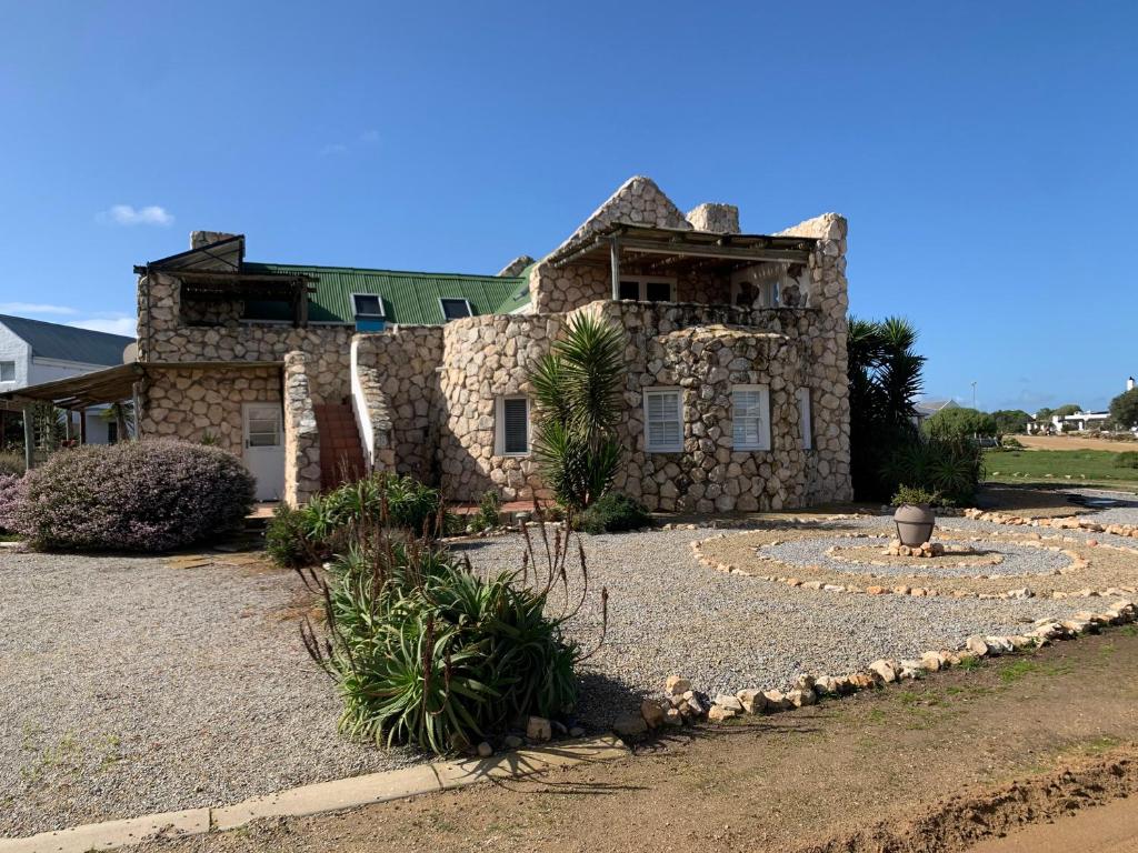 a stone house with a landscaping in front of it at See-Rus Self Catering Seaside Accommodation in Jacobs Bay