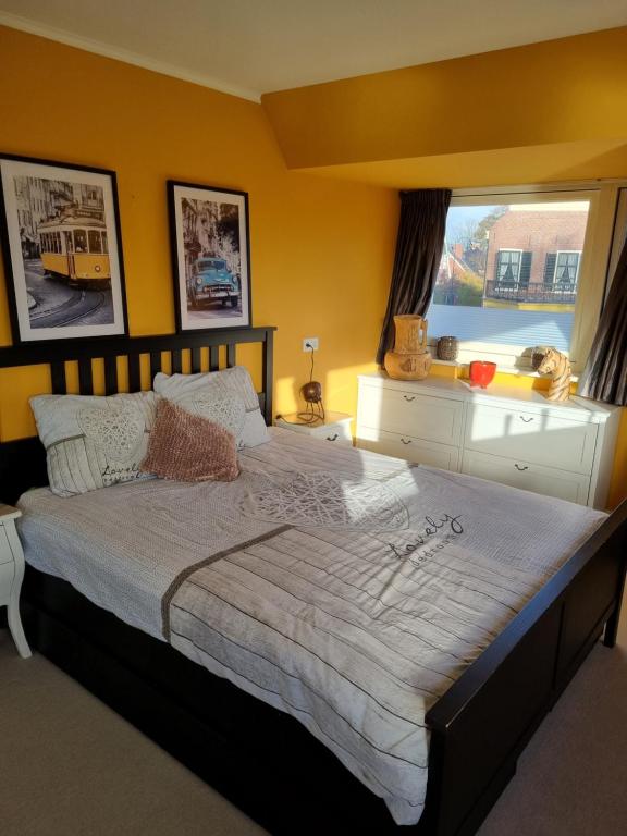 a bedroom with a large bed with a window at De Oude Bakkerij in Onderdendam