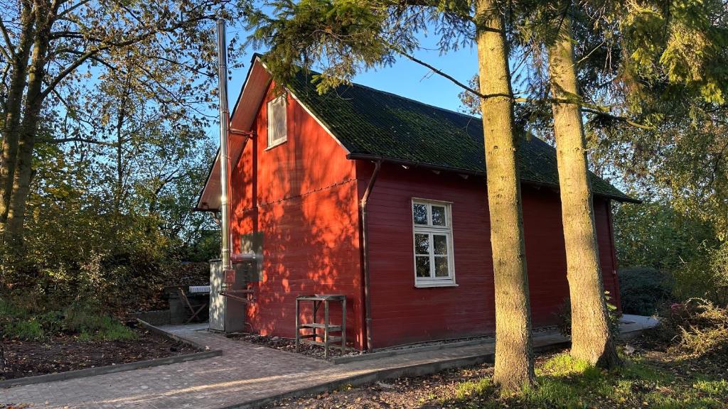 een rood huis met een boom ervoor bij Villa Wewelsburg in Büren