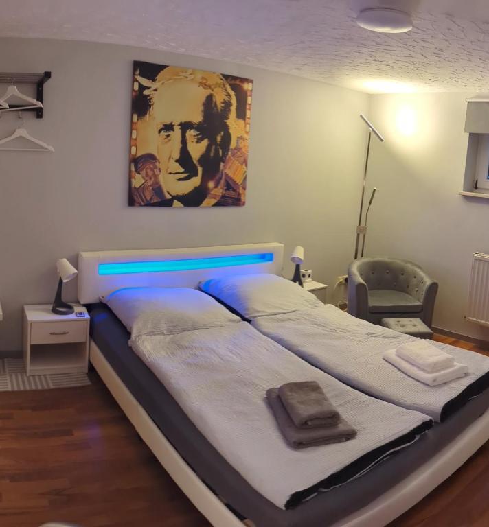 a large bed with a blue headboard in a bedroom at Ferien- Messe- Handwerkerzimmer mit Bad in Harsum