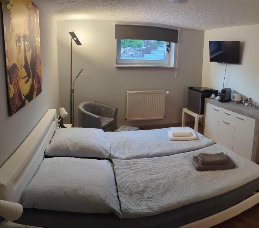 a bedroom with two beds and a television in it at Ferien- Messe- Handwerkerzimmer mit Bad in Harsum