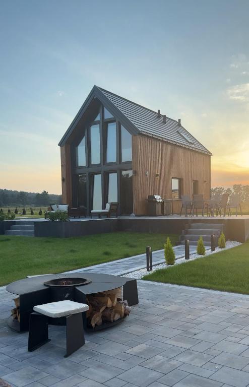 a wooden house with a picnic table in front of it at Golden House Mazury - kajaki, grill, jacuzzi w cenie noclegu! in Liwa