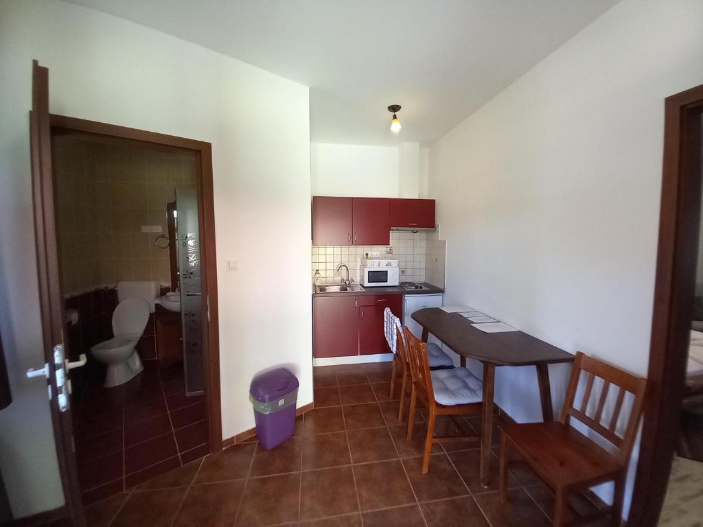 a small kitchen with a table and chairs in a room at Piramis Pihenőpark in Demjén