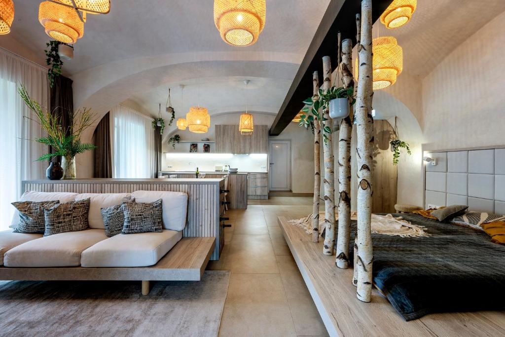 a bedroom with a bed and a couch and trees at Moderní a útulné studio na statku z roku 1880 in Prague