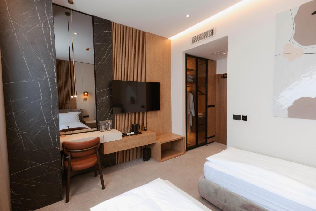 a hotel room with a bed and a desk and a television at Tradicija Hotel in Železnička Stanica Incel