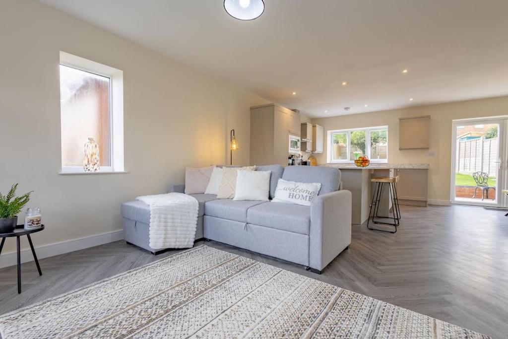 una sala de estar con un sofá y una mesa en North Hill House, en Great Malvern