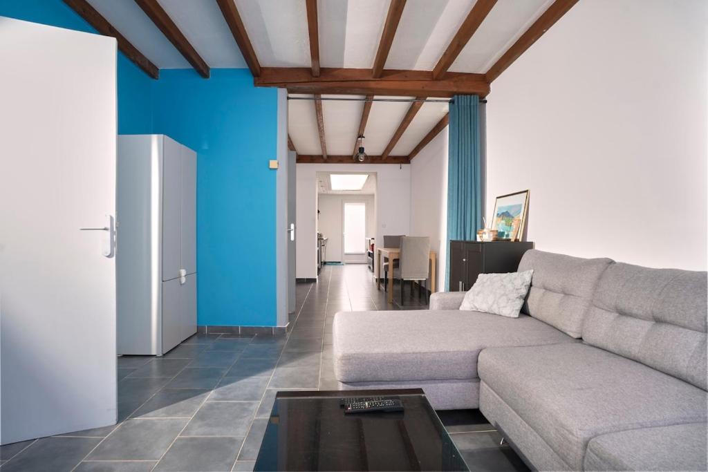 ein Wohnzimmer mit Sofa und Tisch in der Unterkunft Maison 2 ch, 3 lits, près de Lille & transports in Lezennes