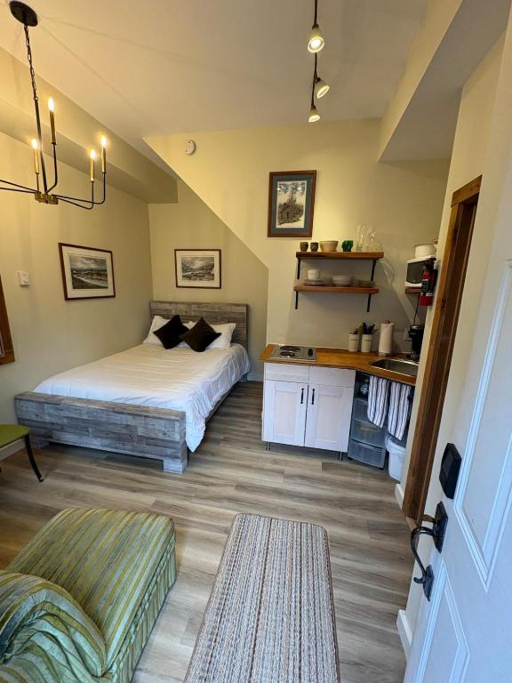 a bedroom with two beds and a table and a couch at Located in Downtown Whitehorse - Basekamp in Whitehorse