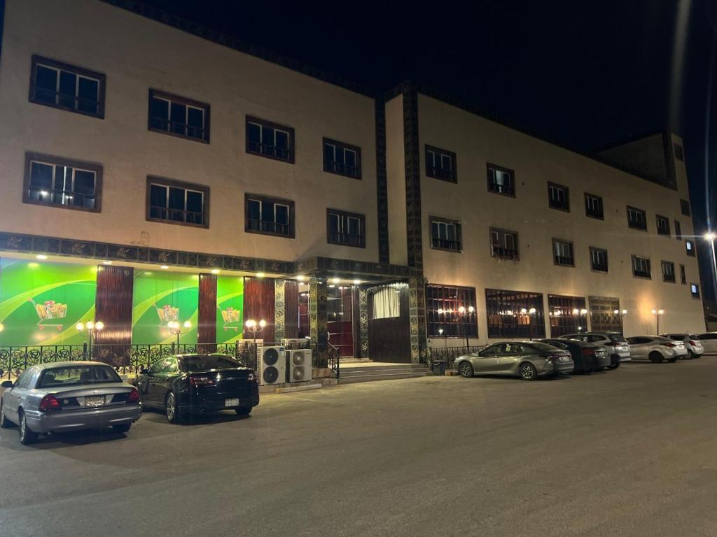 a large building with cars parked in a parking lot at شقق النخبه الجوهره1 in Arar