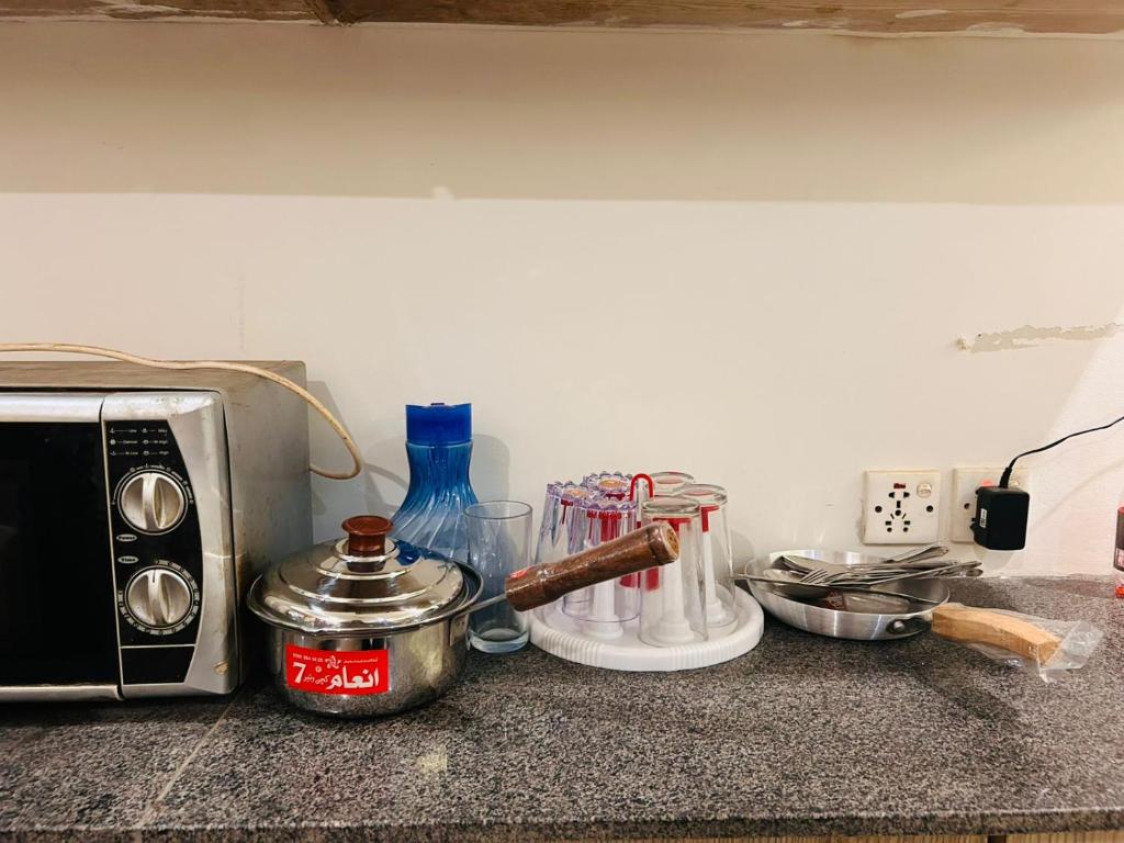 a counter top with a toaster and other kitchen appliances at Fare Home Apartment in Karachi