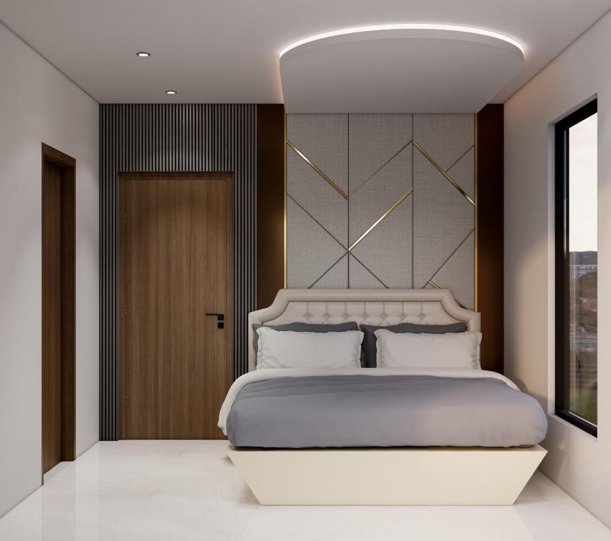 a bedroom with a large white bed and a window at Luxor in Hyderabad