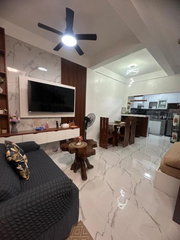 a living room with a couch and a flat screen tv at Amado Apartelle 1 Tagaytay in Kaybagal