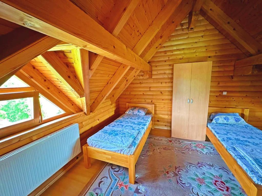 una camera con due letti in una baita di legno di Vikendica sa bazenom Cazin Pecigrad a Cazin