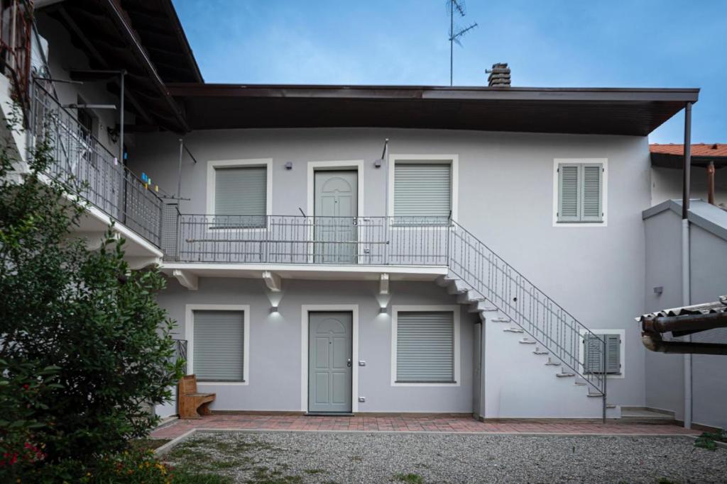une maison blanche avec un escalier sur le côté dans l'établissement Residence Malpensa da Andrea, à Cardano al Campo