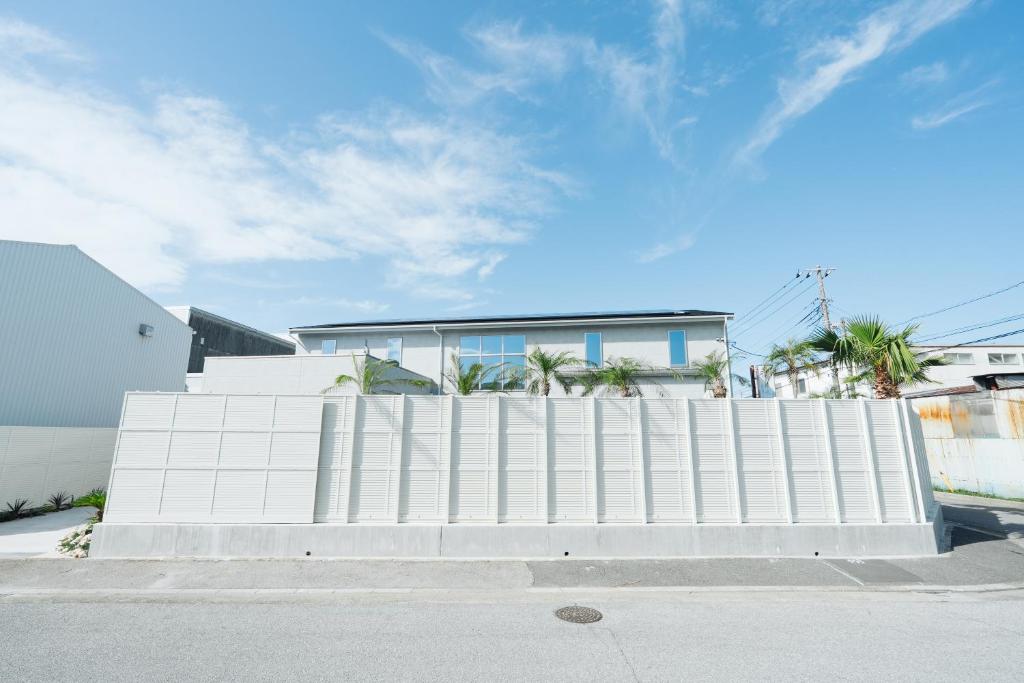 a white fence in front of a house at リトルバーズホステル in Omihachiman