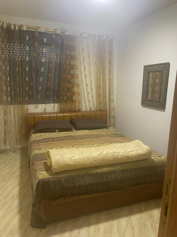 a bedroom with two beds and a curtain at Laziza in Temara