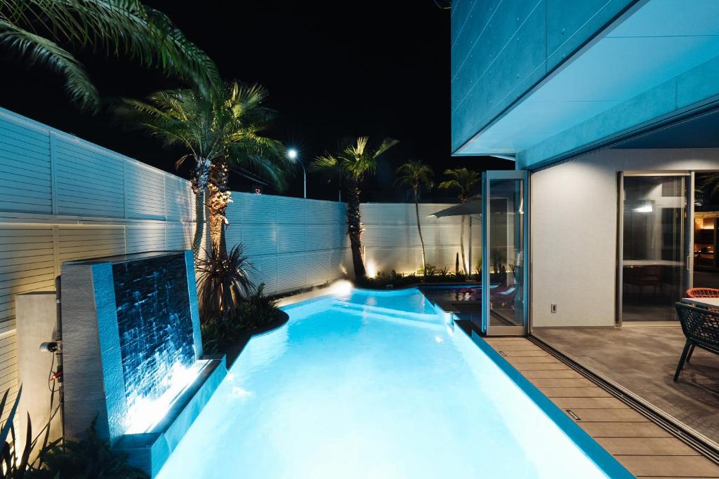 una piscina en el patio trasero de una casa por la noche en ウォーターハウス記念館, en Omihachiman