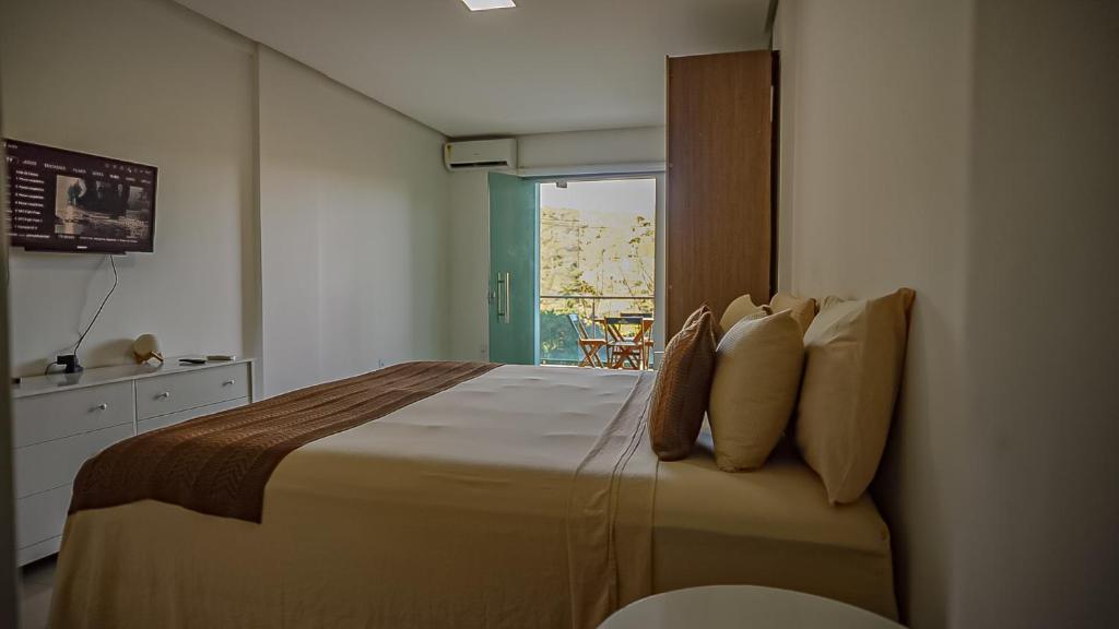 una camera da letto con un letto grande con una finestra di Vila Fox Suites com Varanda a Lençóis