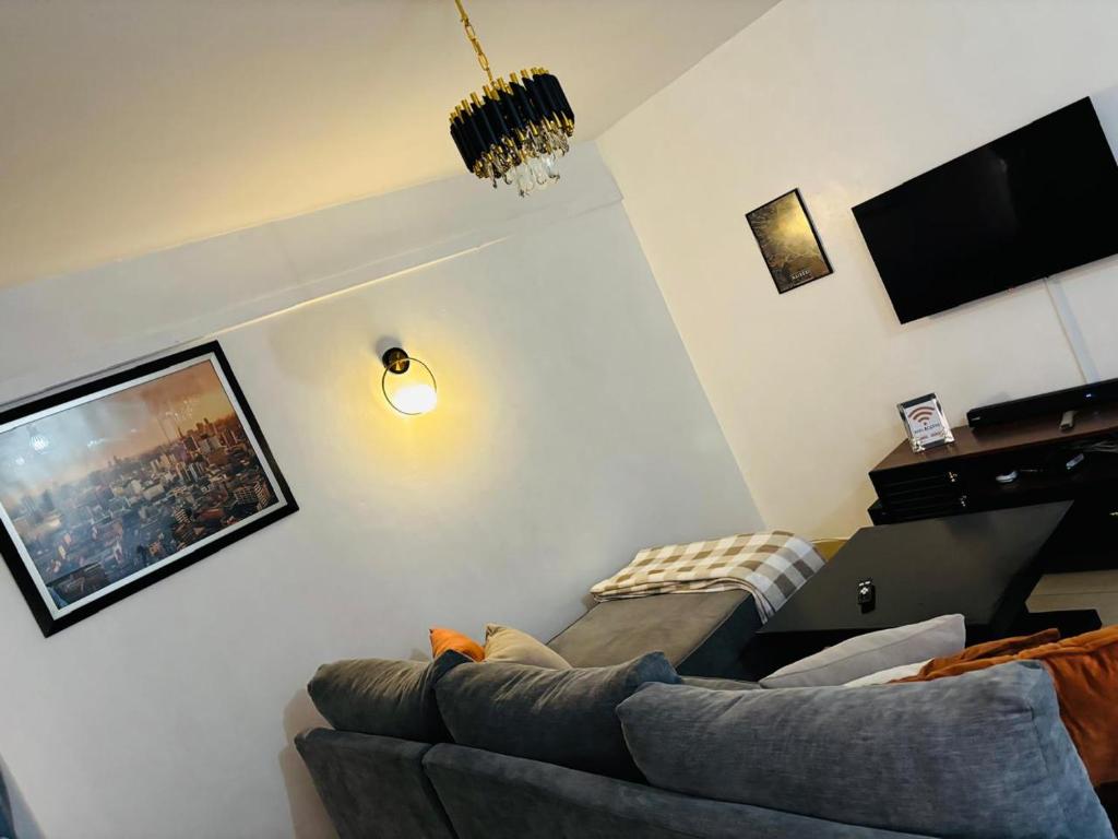 a living room with a couch and a tv at Valentine's Suite in Nairobi