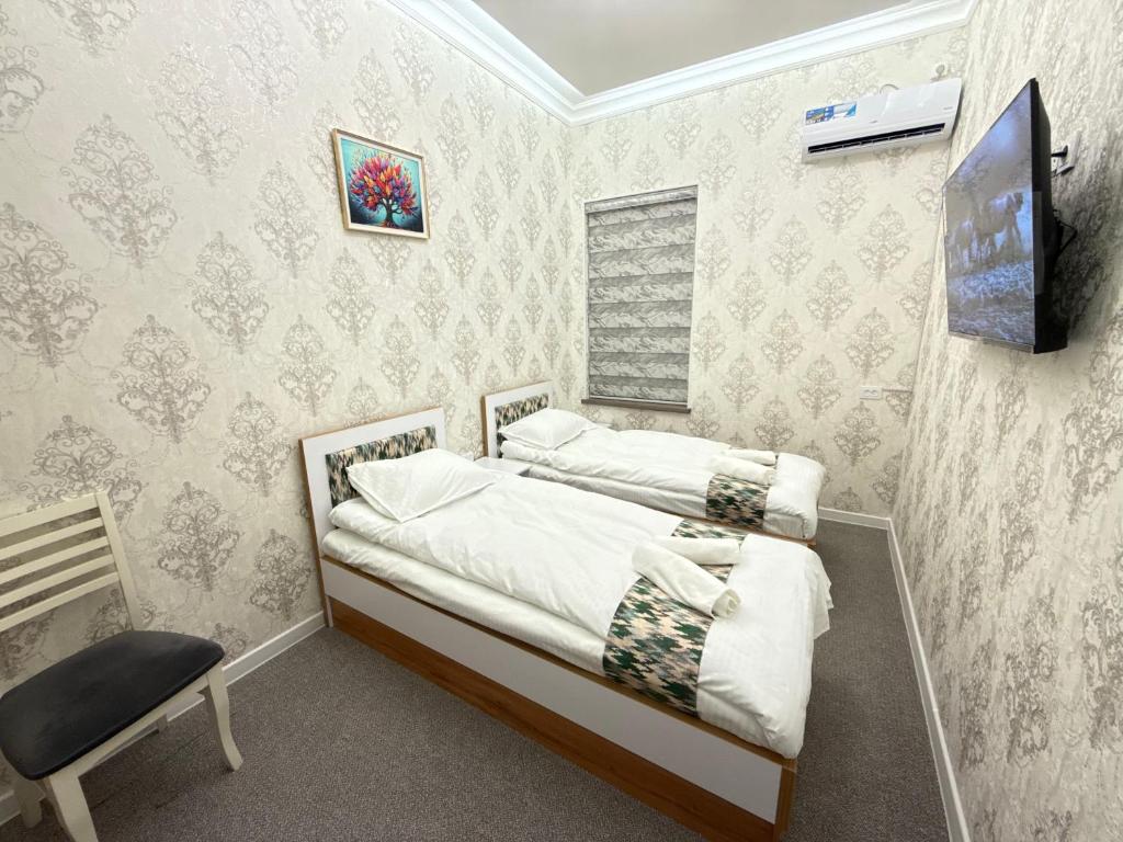 a small bedroom with a bed and a chair at Bekh House in Samarkand