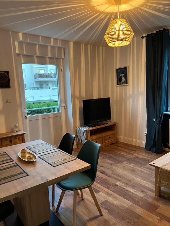 a living room with a table and a television at Chez F & G in Sélestat