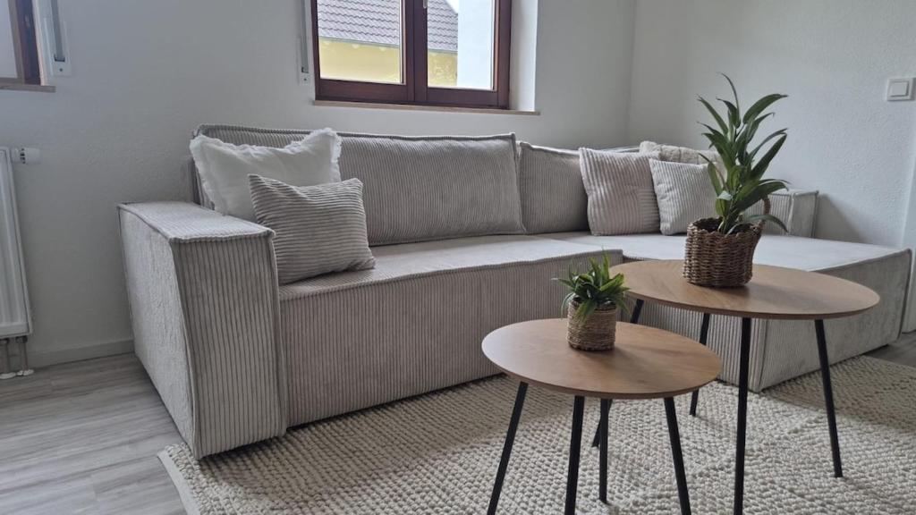 Una sala de estar con un sofá y dos mesas. en Hyggeapartment Gailingen - Dein Rückzugsort am Hochrhein, en Gailingen