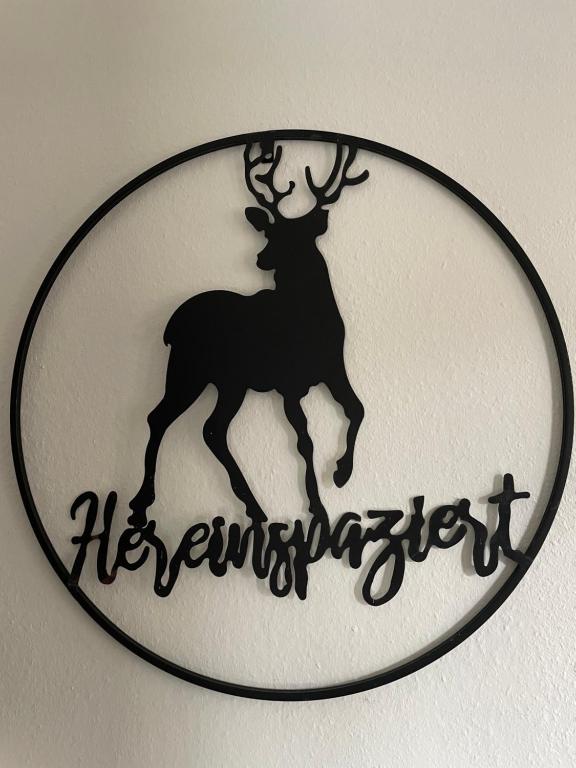 a sign with a reindeer on a wall at Ruhiges Apartment in Weissach - Nähe Porsche in Weissach