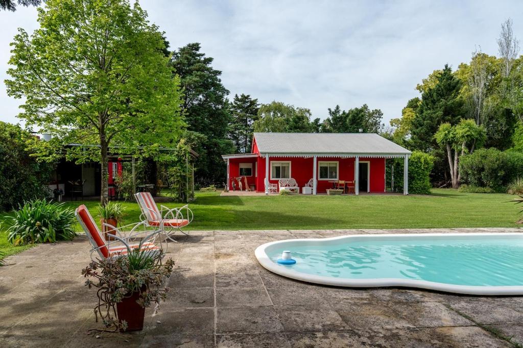 ein rotes Haus mit Pool davor in der Unterkunft Casa de Campo Duggan - San Antonio de Areco in Duggan