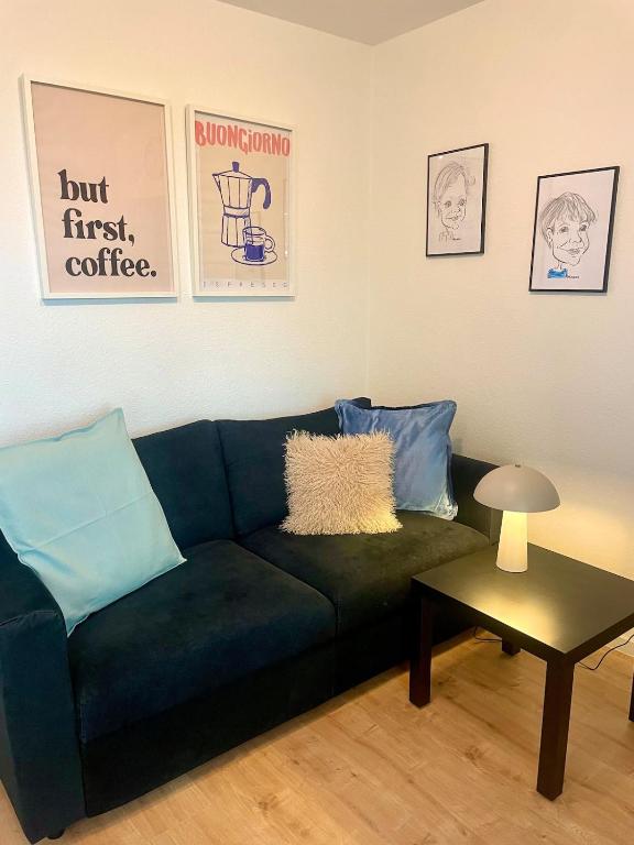 a living room with a blue couch and a table at Your home away from home in Osnabrück