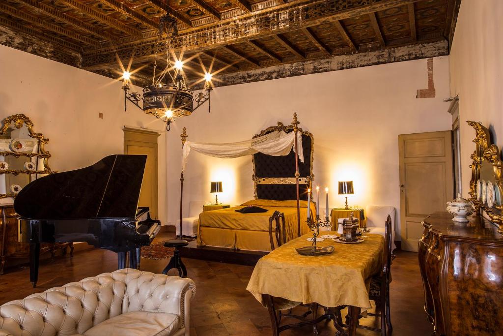 ein Schlafzimmer mit einem Bett und einem Klavier und einem Bett sidx sidx sidx in der Unterkunft Castello del Capitano delle Artiglierie in Castrocaro Terme