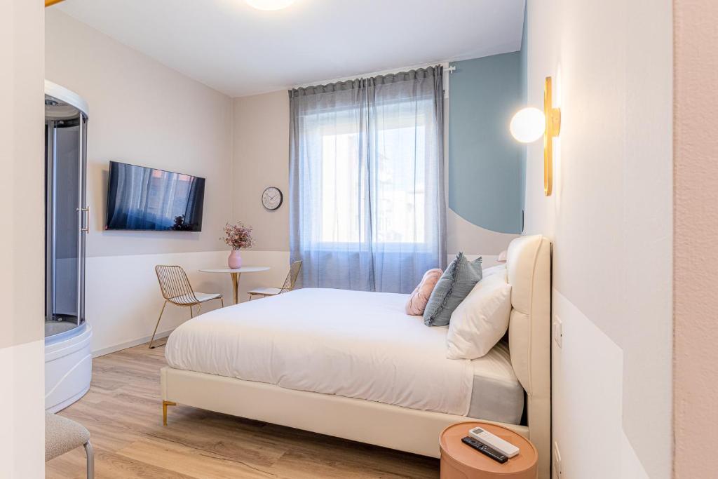 a white bedroom with a bed and a window at Venus Suite - Romantic Private Spa - Centro Livorno in Livorno