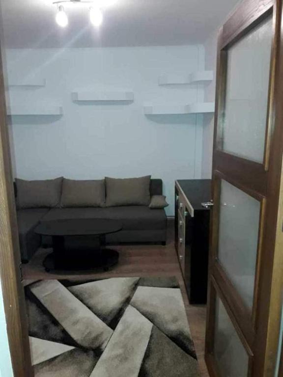 a living room with a couch and a table at Apartament Decebal- 2 dormitoare in Bistriţa