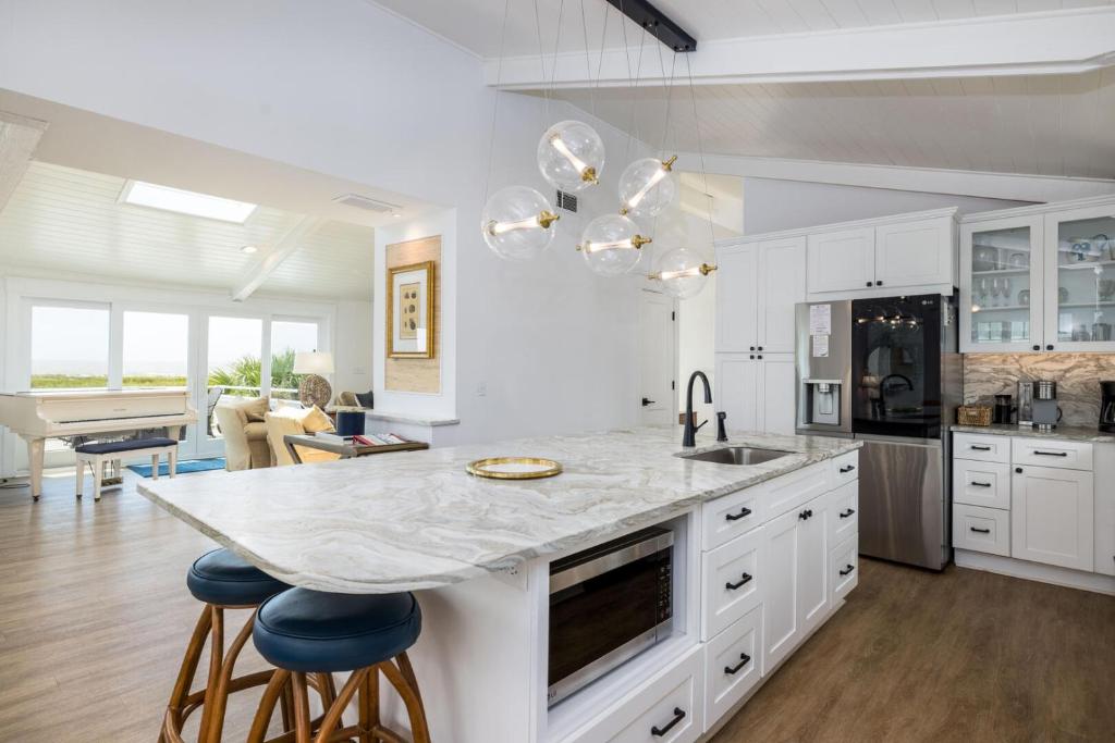 een keuken met witte kasten en een marmeren aanrecht bij 715 Winter Trout in Fripp Island