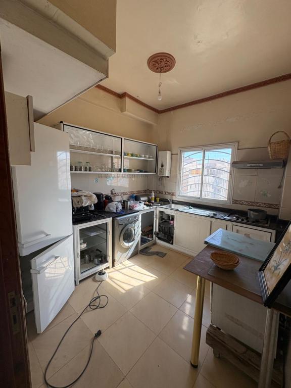 フェズにあるApparemment à 100 mètres du complexe de fesの広いキッチン(白い家電製品、テーブル付)