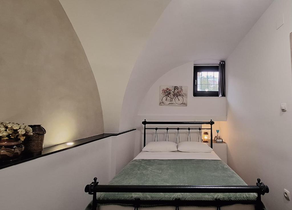 een kleine slaapkamer met een bed in een witte kamer bij THOMAS LUXURY APARTMENT in the historical center of Ioannina in Ioannina