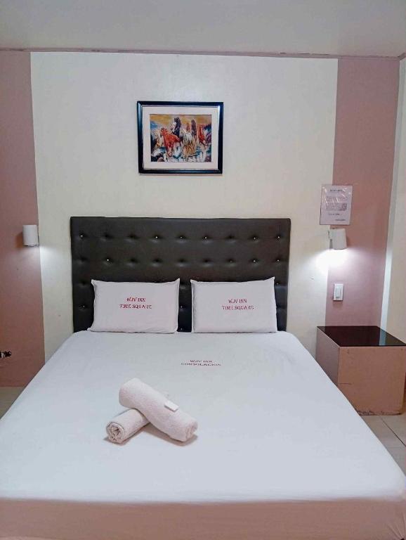 a white bed with a white towel on it at Wjv Inn Time Square in Mandaue City