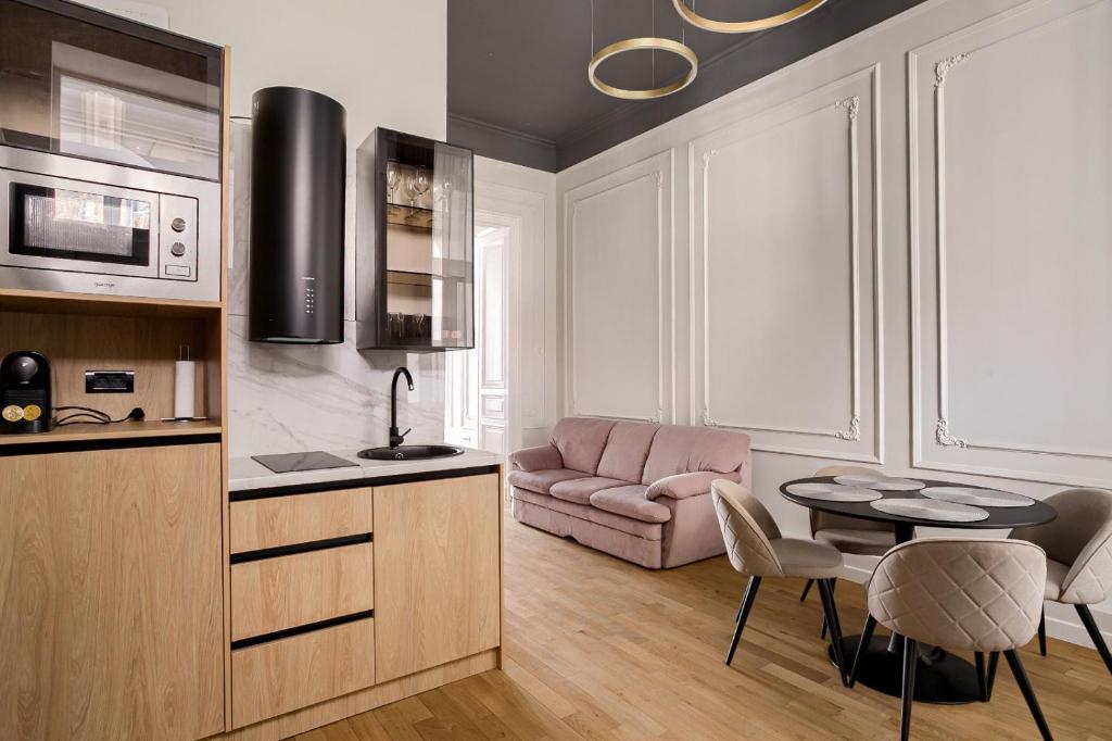 a kitchen and living room with a table and a couch at Bulevard Suite in Arad