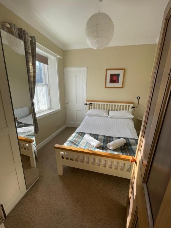 une chambre avec un lit et une grande fenêtre dans l'établissement Character cottage in centre of Moffat, à Moffat