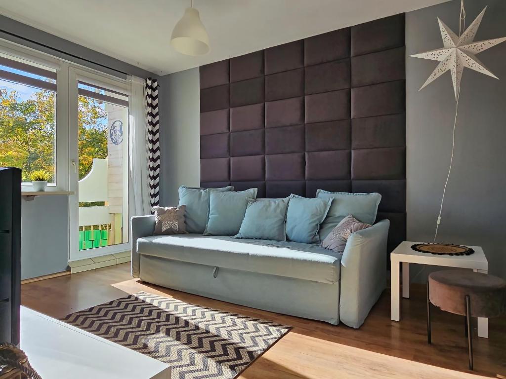a living room with a blue couch and a table at Apartament Dzień dobry in Wałbrzych