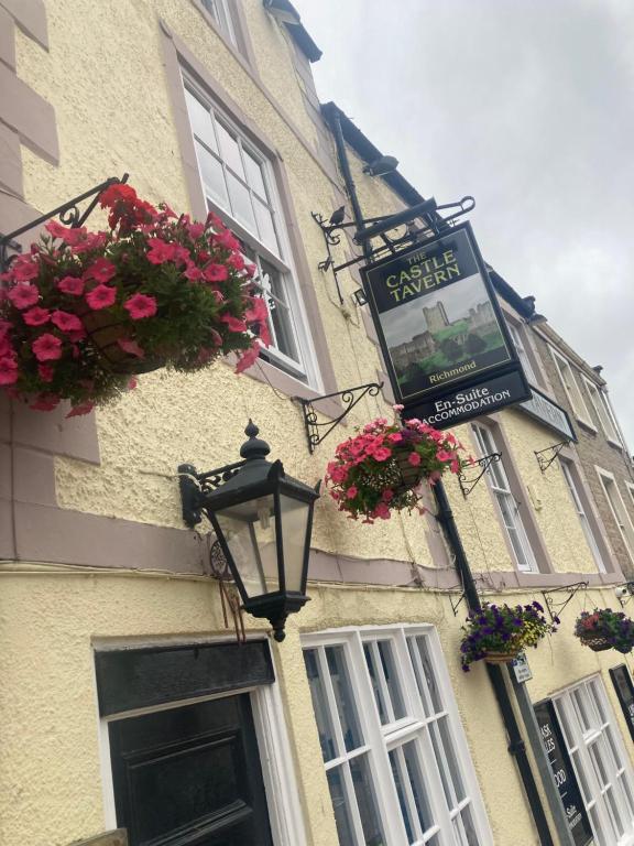 a building with flowers and a street sign on it at The Castle Tavern Richmond in Richmond