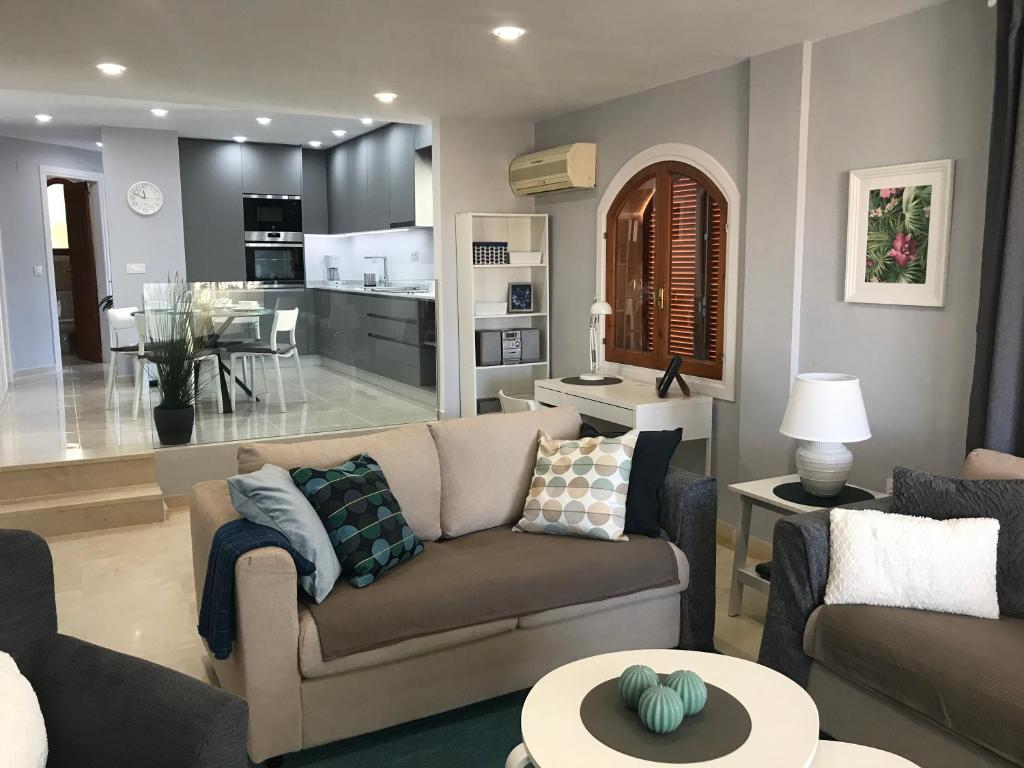 a living room with a couch and a kitchen at La Manga Club, Las Palmeras 12 in Cartagena