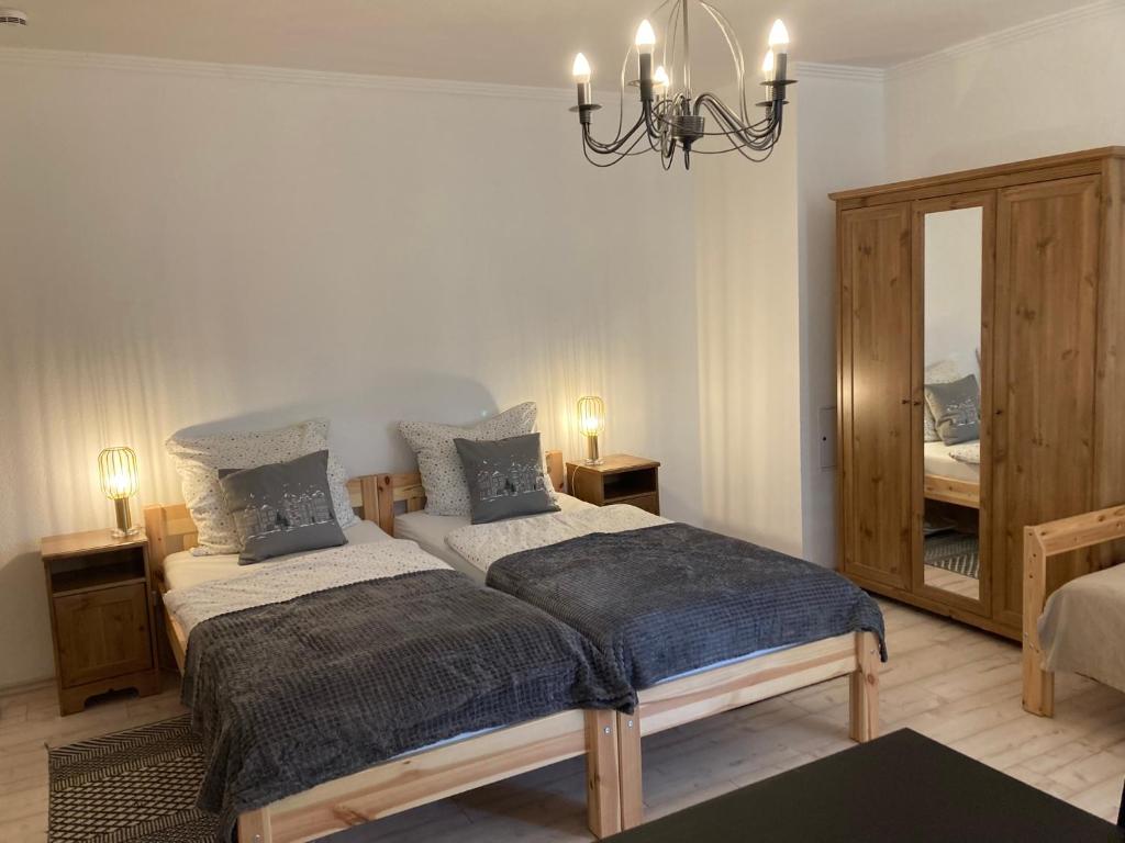 a bedroom with two beds and a mirror at Alter Gutshof Kromlau Direkt am Schloss und Rhododendronpark, Terasse und Parkplatz in Kromlau
