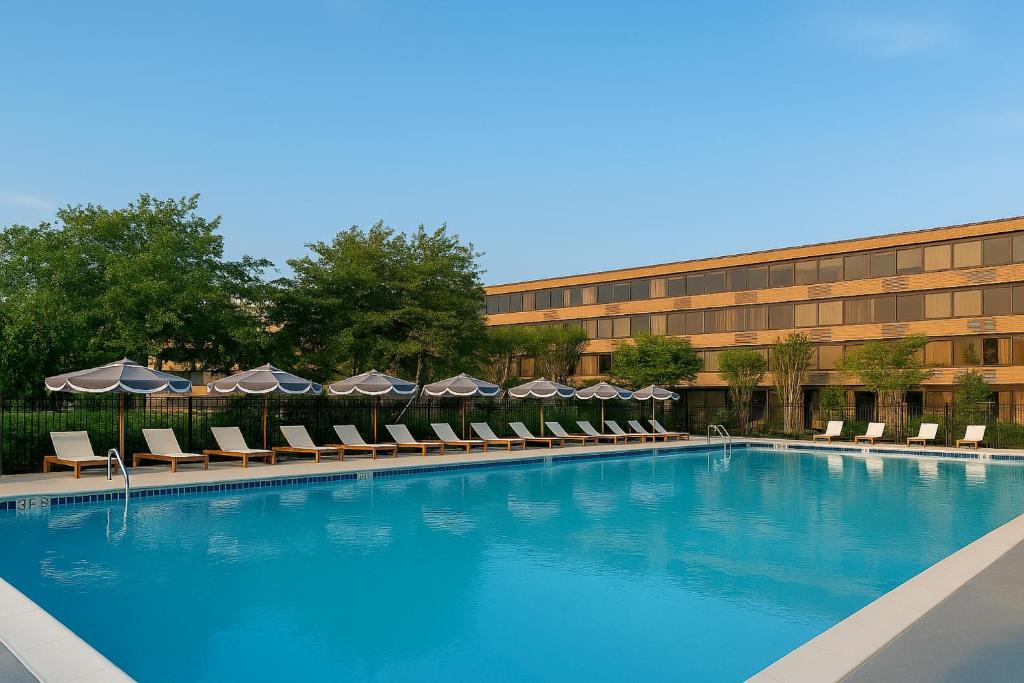 a swimming pool with chairs and umbrellas in front of a building at Solomons Inn Resort and Marina in Solomons